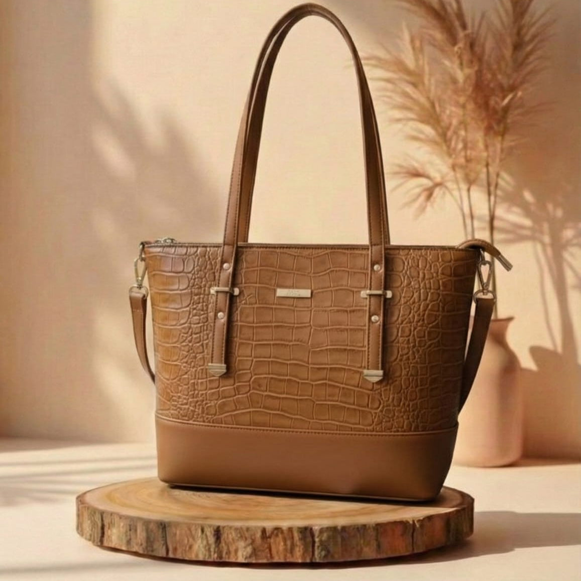 Brown leather handbag with crocodile texture on a wooden stand