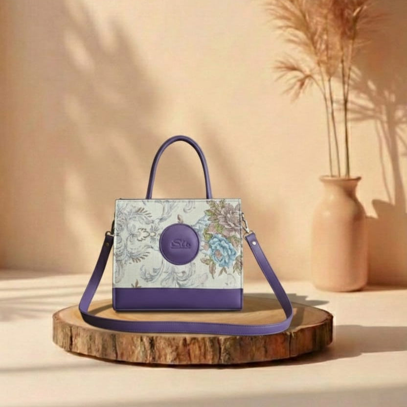 purple Floral-patterned handbag with a purple handle and strap on a wooden stand against a beige background.