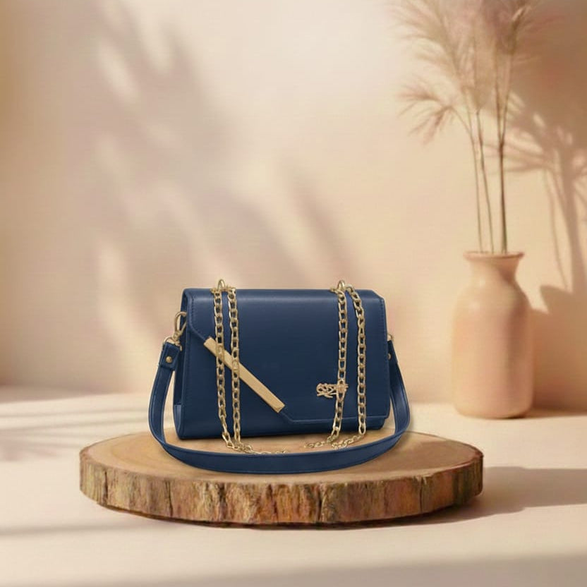 Blue handbag with gold chain on a wooden stand against a beige background
