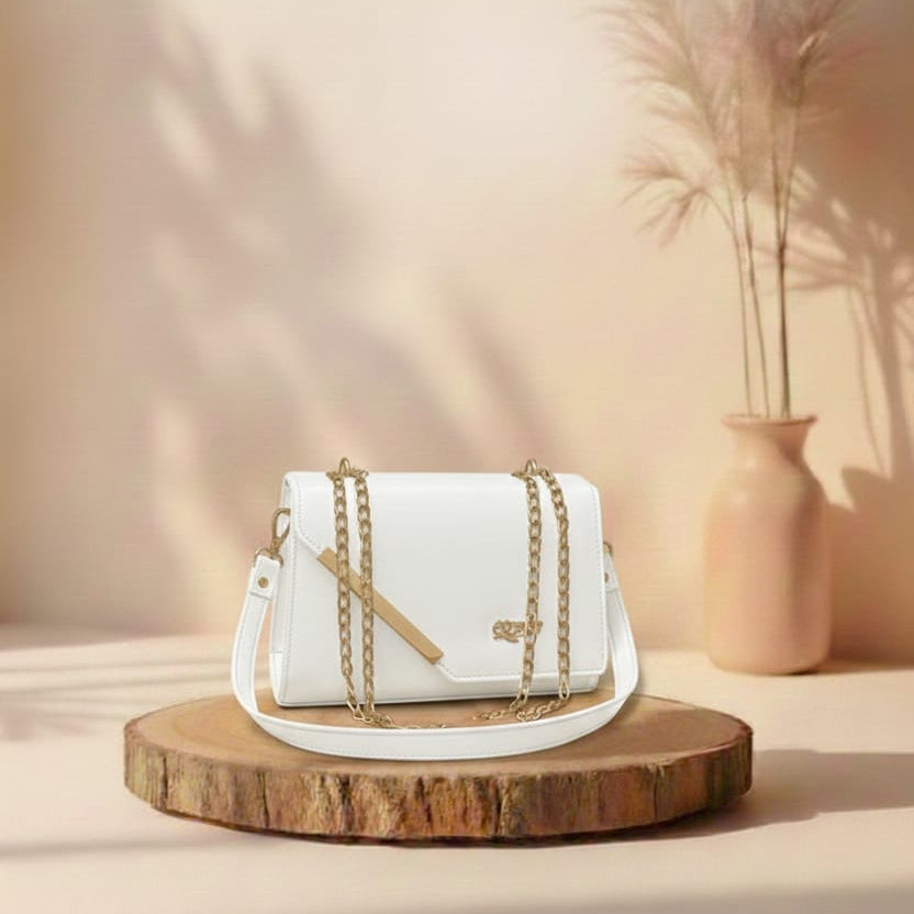White handbag with gold chain on a wooden stand against a beige background