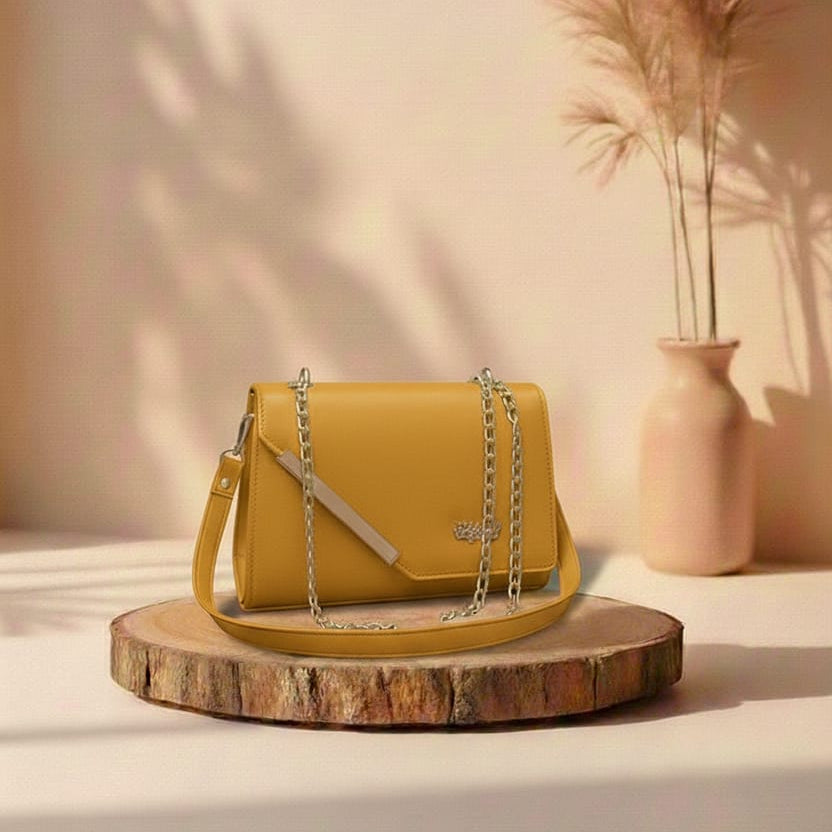 Yellow handbag on a wooden platform with a vase and dried plants in the background