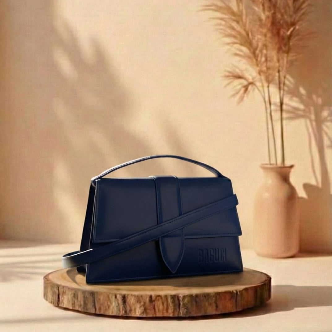 navy Blue handbag on a wooden stand with a beige wall and vase in the background